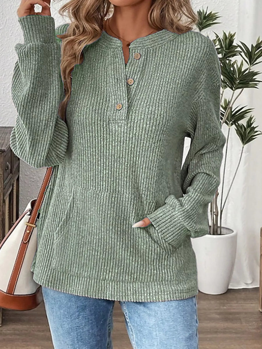 Light green ribbed long-sleeve top with button detail and front pocket.