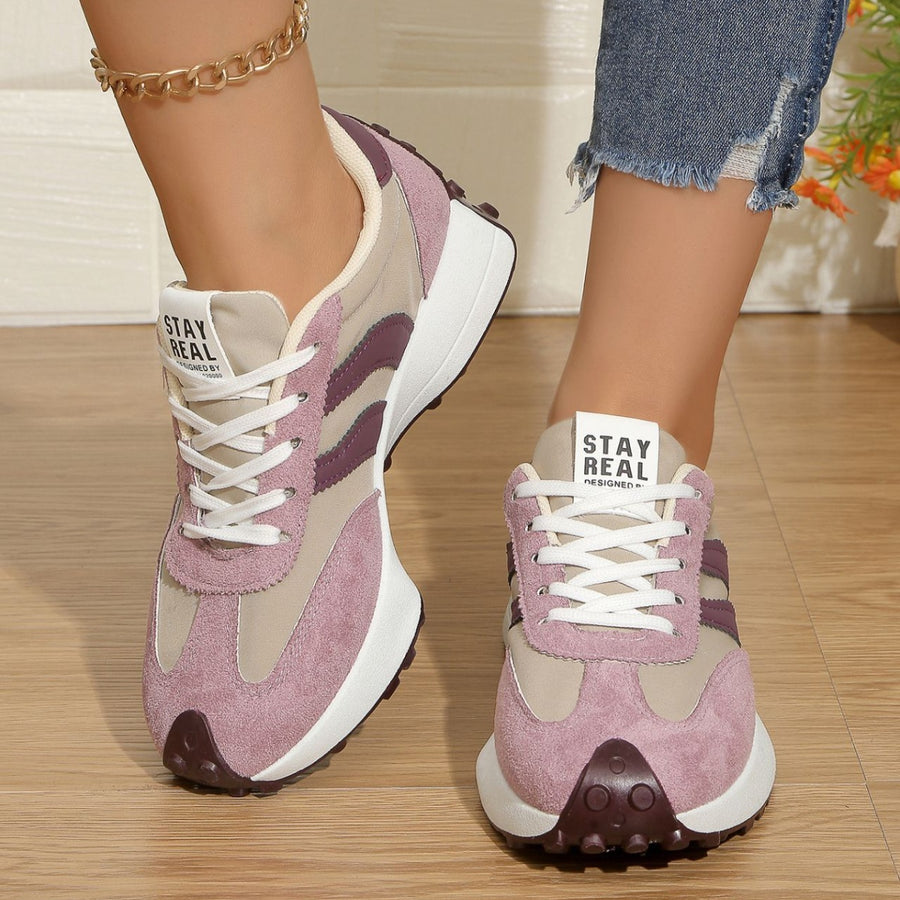 Lace up round toe sneakers in pink and beige with purple accents and a chunky sole.