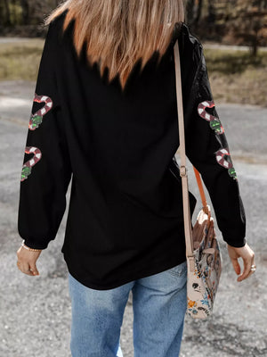 Black sweatshirt with sequin candy cane heart detail on sleeves.