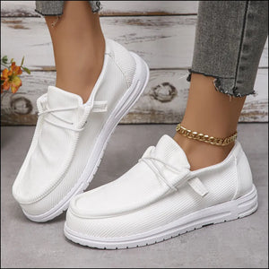 White textured slip-on espadrille sneakers with white laces and soles.
