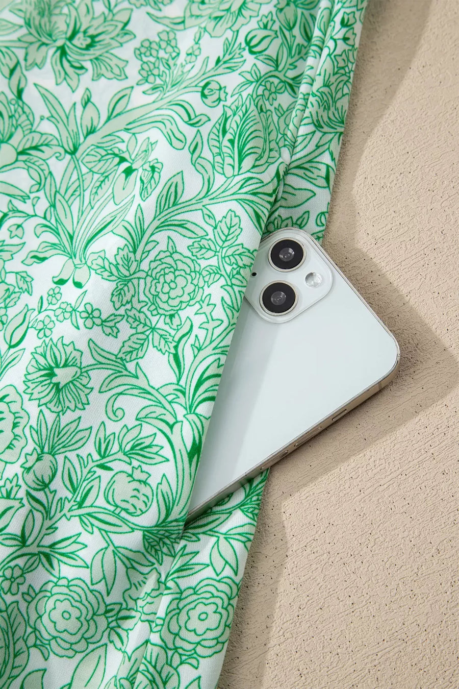 Botanical print midi dress with pockets, showing a phone tucked into the side pocket.