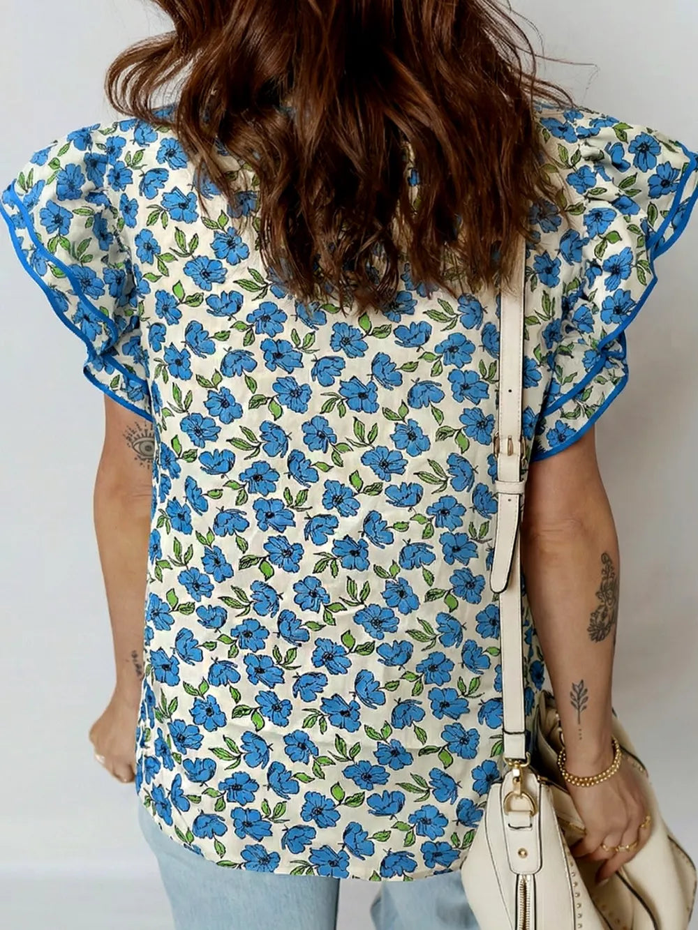 Floral ruffle sleeve blouse with blue floral print and contrast trim.