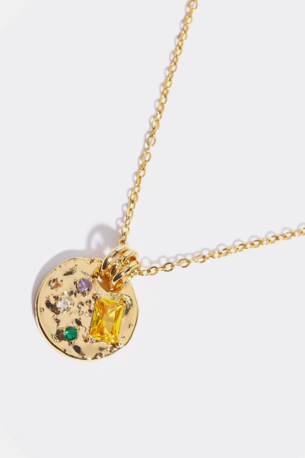 Gold textured disc pendant necklace with colorful gemstone accents