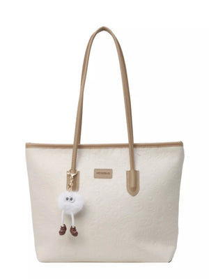 Embossed PU leather tote bag in cream with tan trim and a fluffy charm.