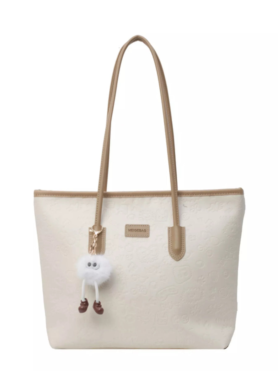 Embossed PU leather tote bag in cream with tan trim and a fluffy charm.