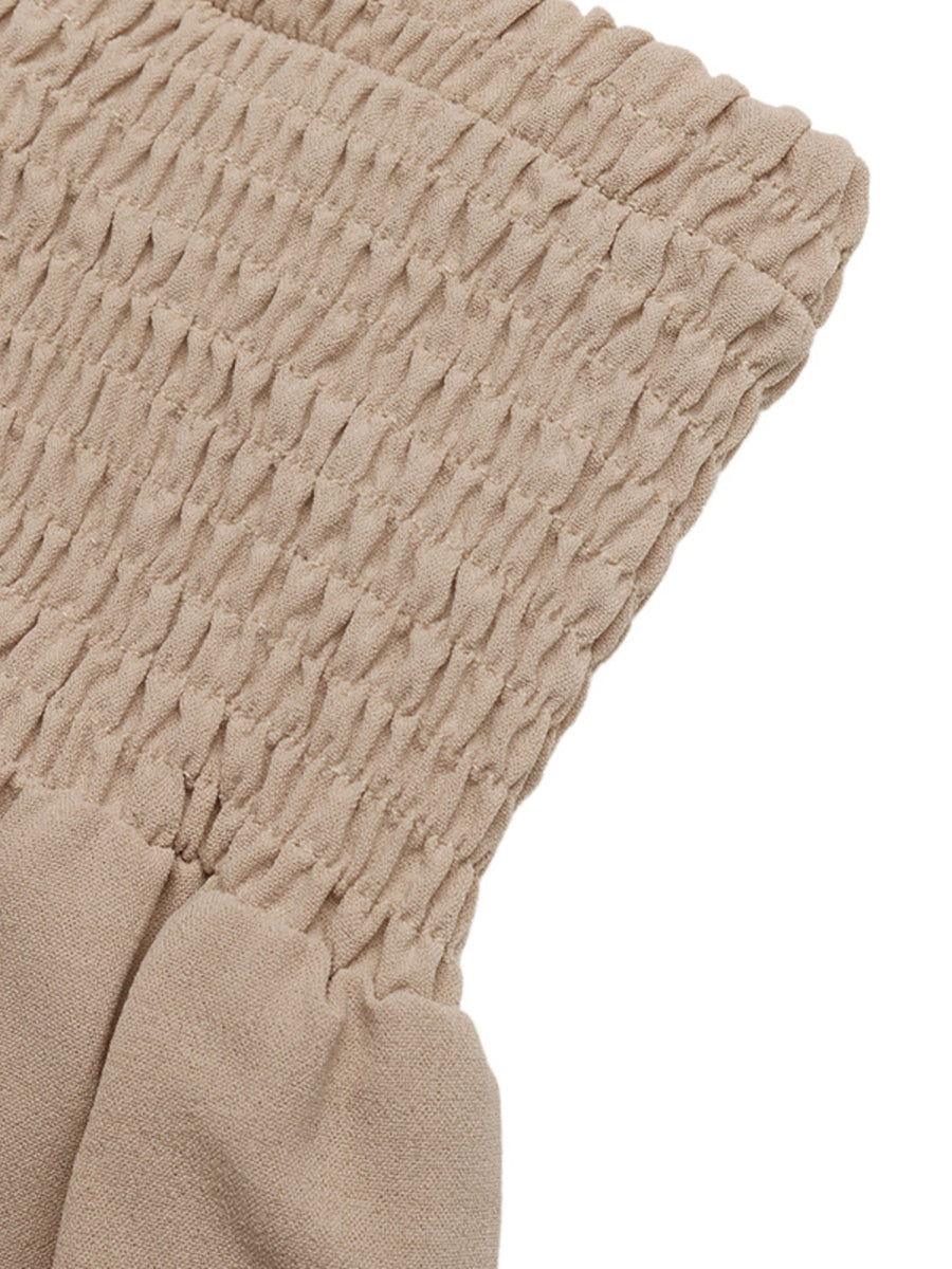 Smocked waist wide leg trousers in beige cotton, showing textured smocking detail.