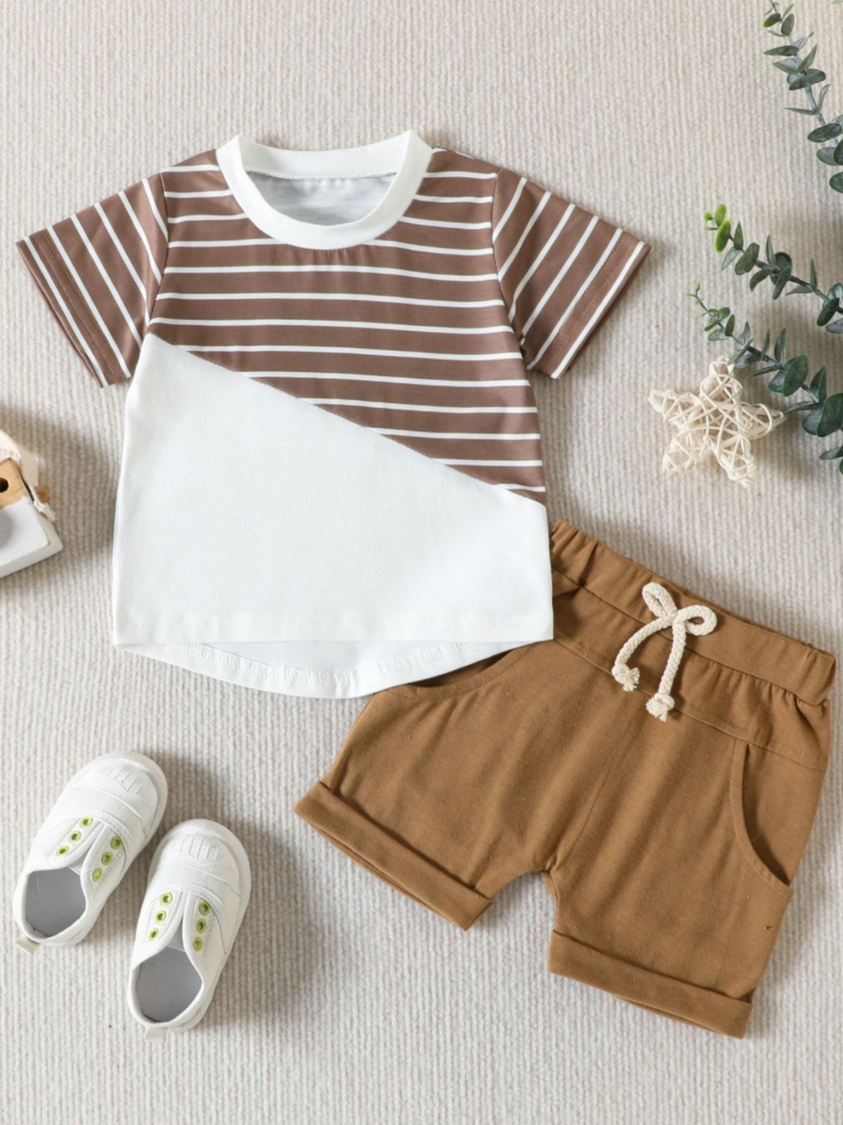 Baby two-piece set with brown and white striped top and brown shorts.