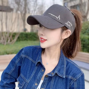 Dark gray baseball cap with white embroidered logo and ponytail opening