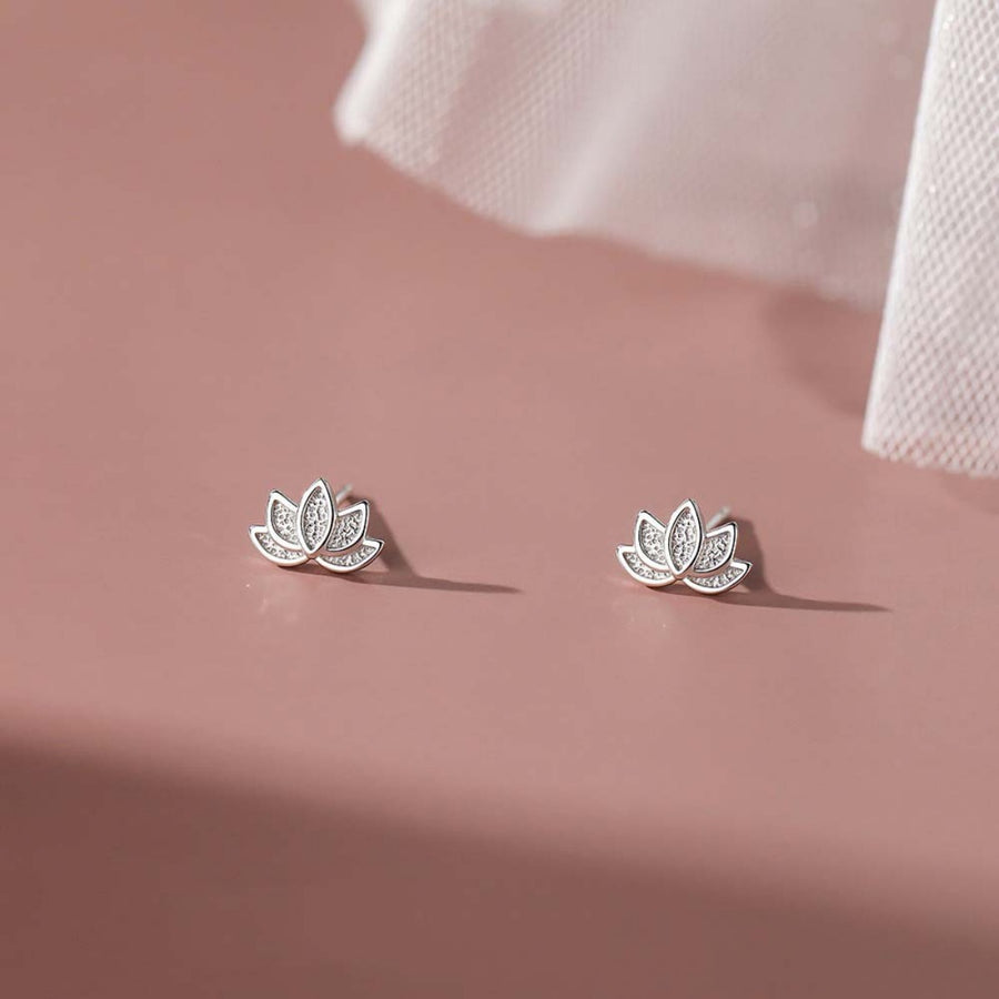 Silver lotus flower stud earrings with delicate petal detail.