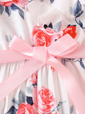 Toddler dress with floral print, ruffle trim, and pink bow detail.