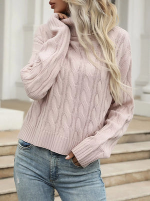 Pink cable knit turtleneck sweater with ribbed cuffs and hem.