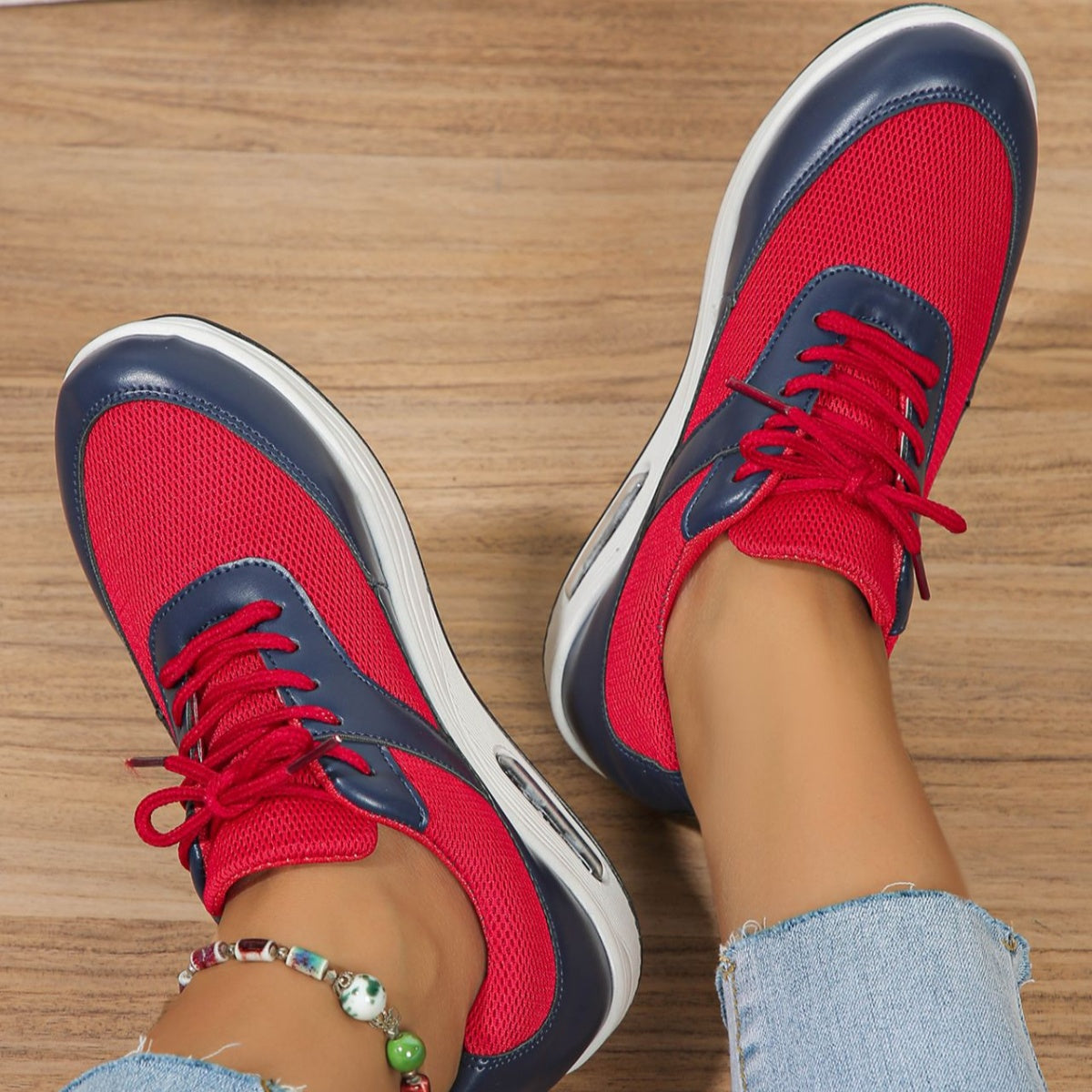 Red and navy lace-up wedge sneakers with breathable mesh and leather accents.