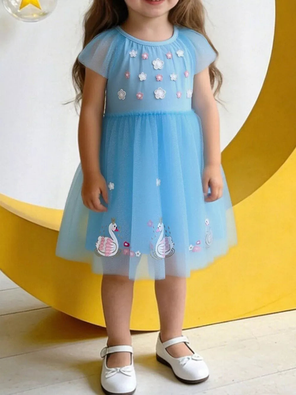 Blue tulle baby dress with cap sleeves, floral appliques, and swan embroidery.