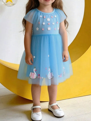 Blue tulle baby dress with cap sleeves, floral appliques, and swan embroidery.