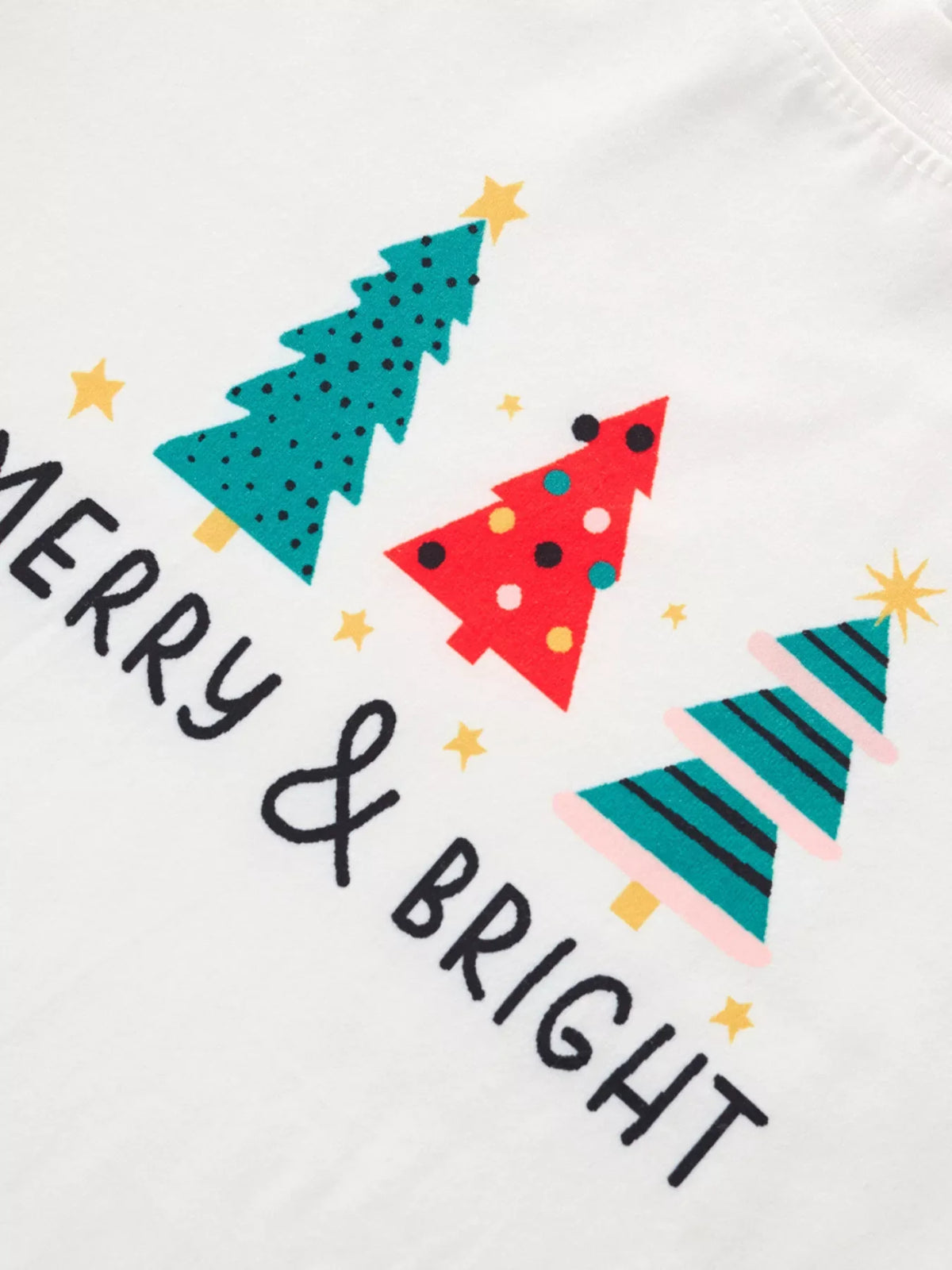 Children's white long-sleeve pajamas with Merry & Bright text and colorful Christmas tree prints.