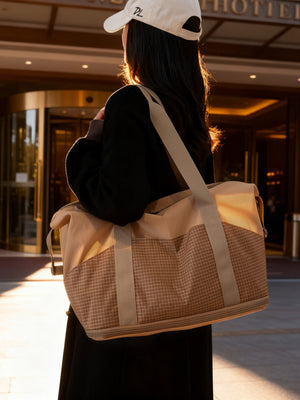 Spacious nylon travel duffel bag in khaki with grid pattern detail and tan straps.