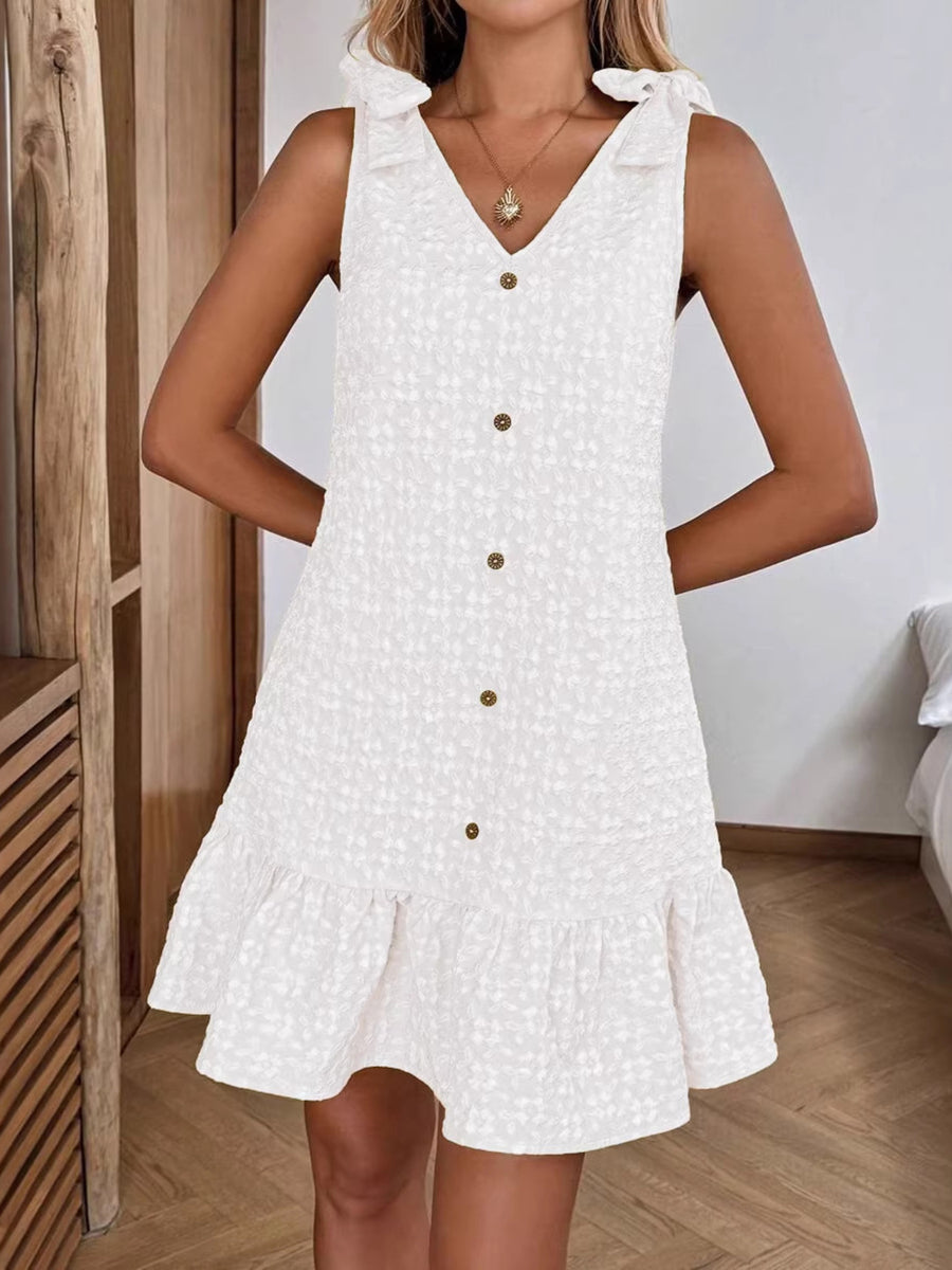 White button-front V-neck ruffled dress with tie shoulders and textured fabric.