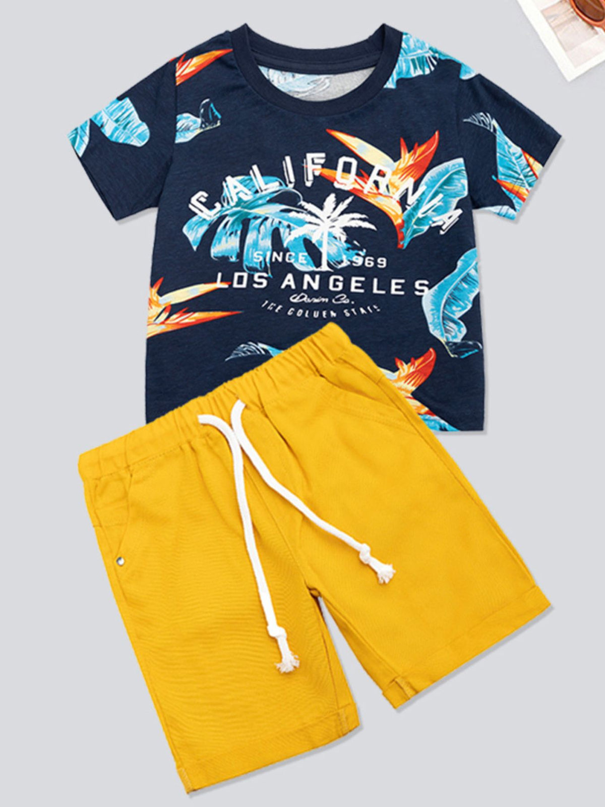 Boys' cotton two-piece set with navy tropical print t-shirt and yellow drawstring shorts.