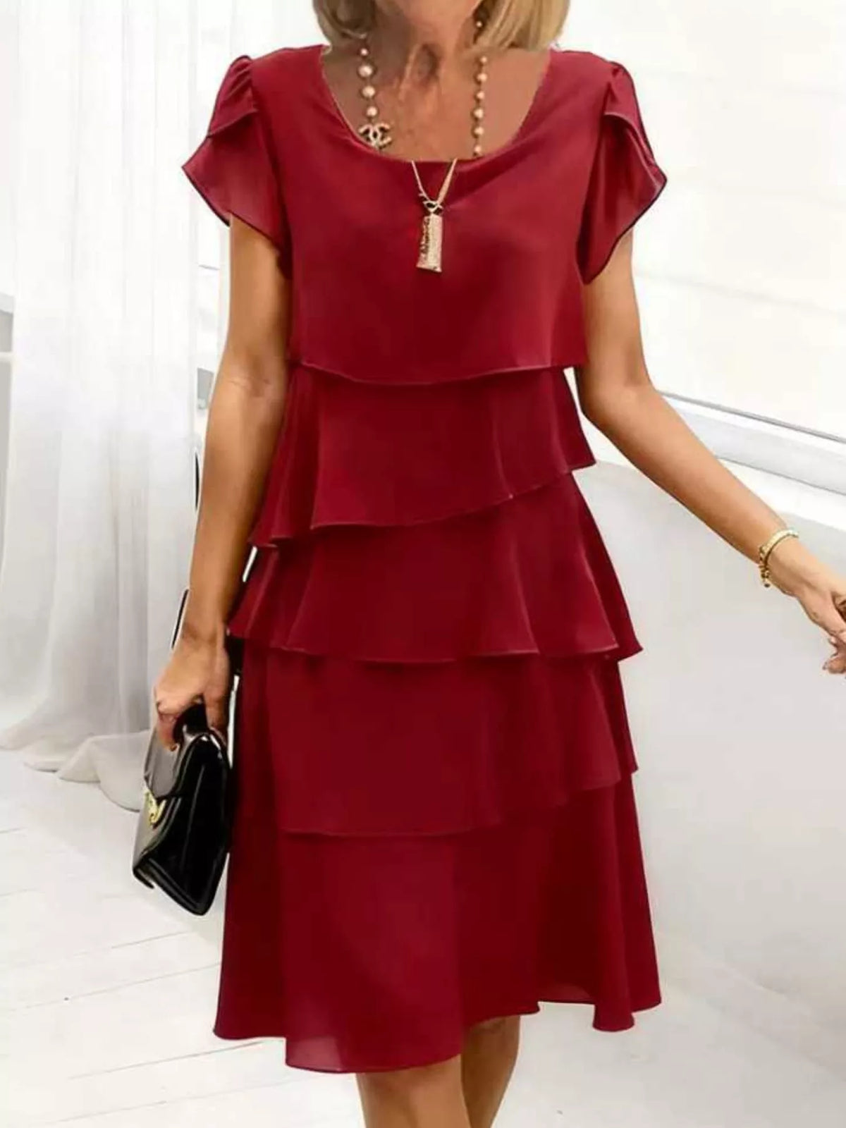 Burgundy tiered petal sleeve dress with a round neckline and a flowing skirt.