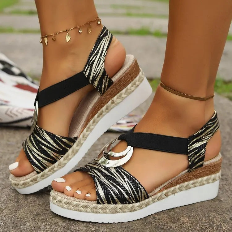 Metallic accent espadrille wedges with black and gold zebra print straps and a cork wedge.