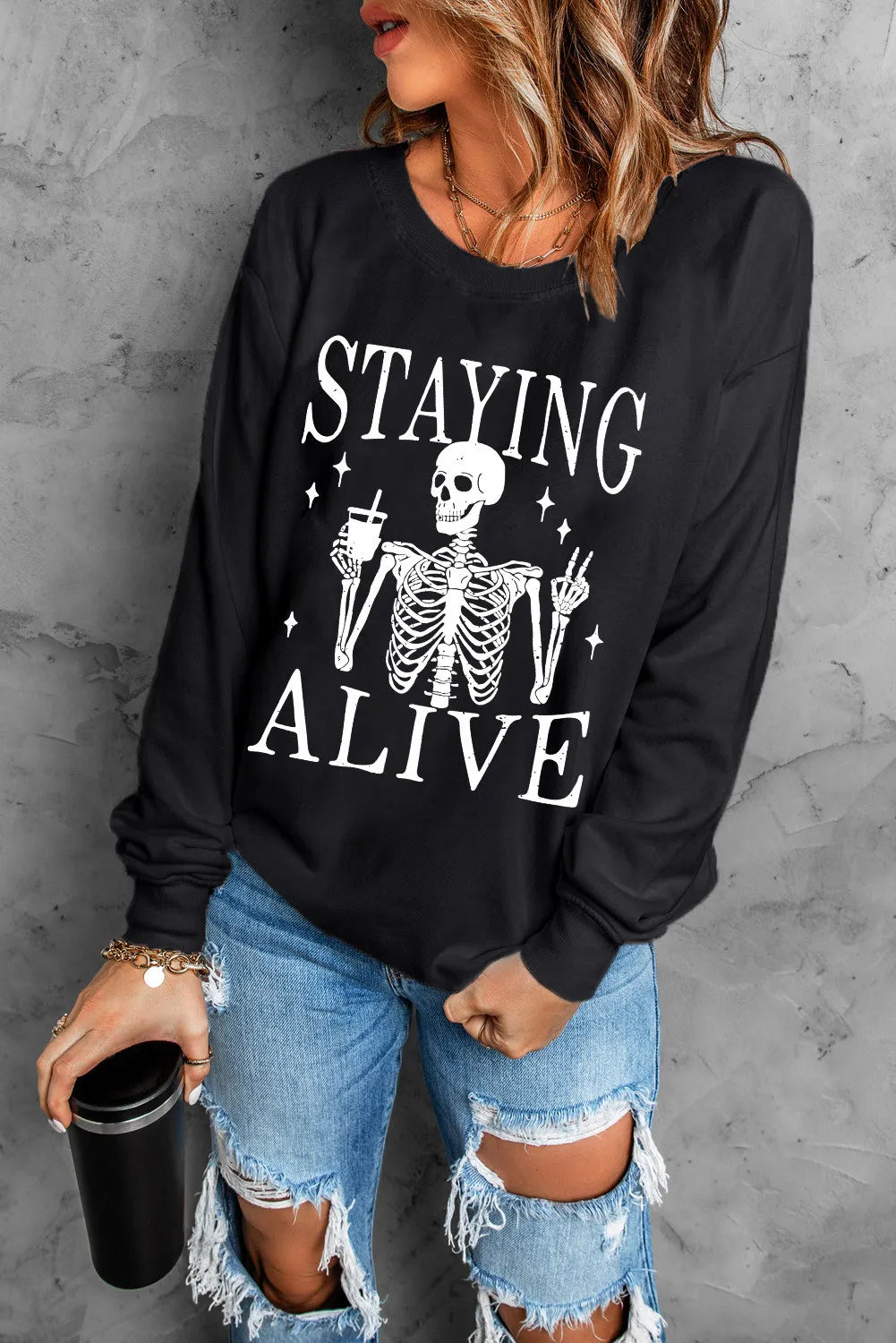 Black graphic sweatshirt with skeleton holding drink and peace sign.