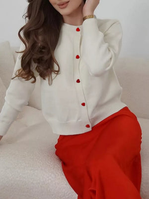 Cream long sleeve cardigan with red heart buttons, crew neck, button front.