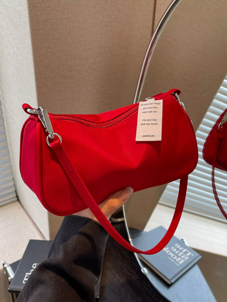 Red nylon mini crossbody bag with a compact design and a white tag.