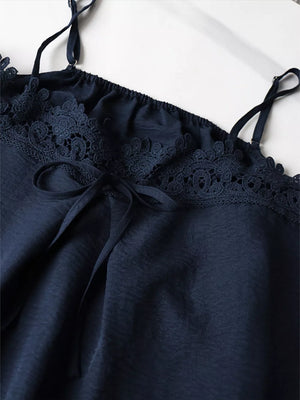 Navy camisole with lace trim and adjustable straps, featuring a tie detail.