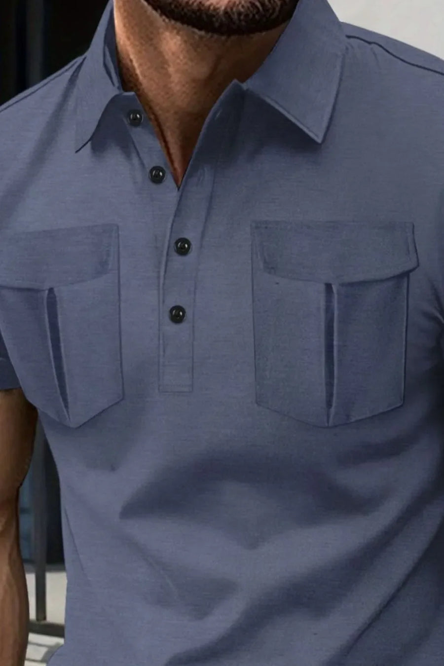 Dusty blue polo shirt with two flap chest pockets and button placket.