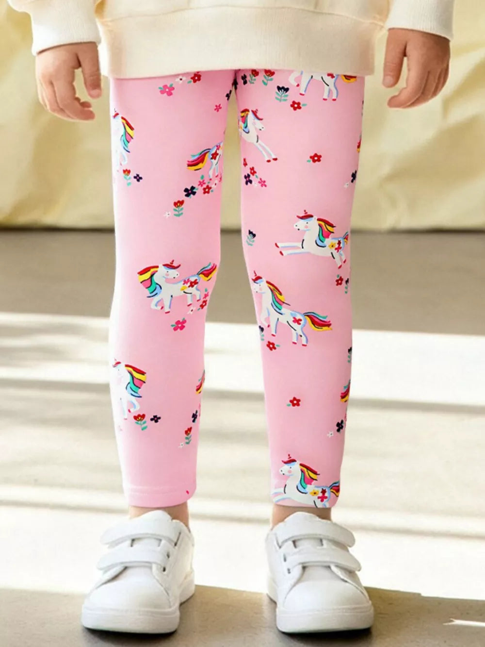 Toddler pink cotton leggings with a unicorn and floral print.