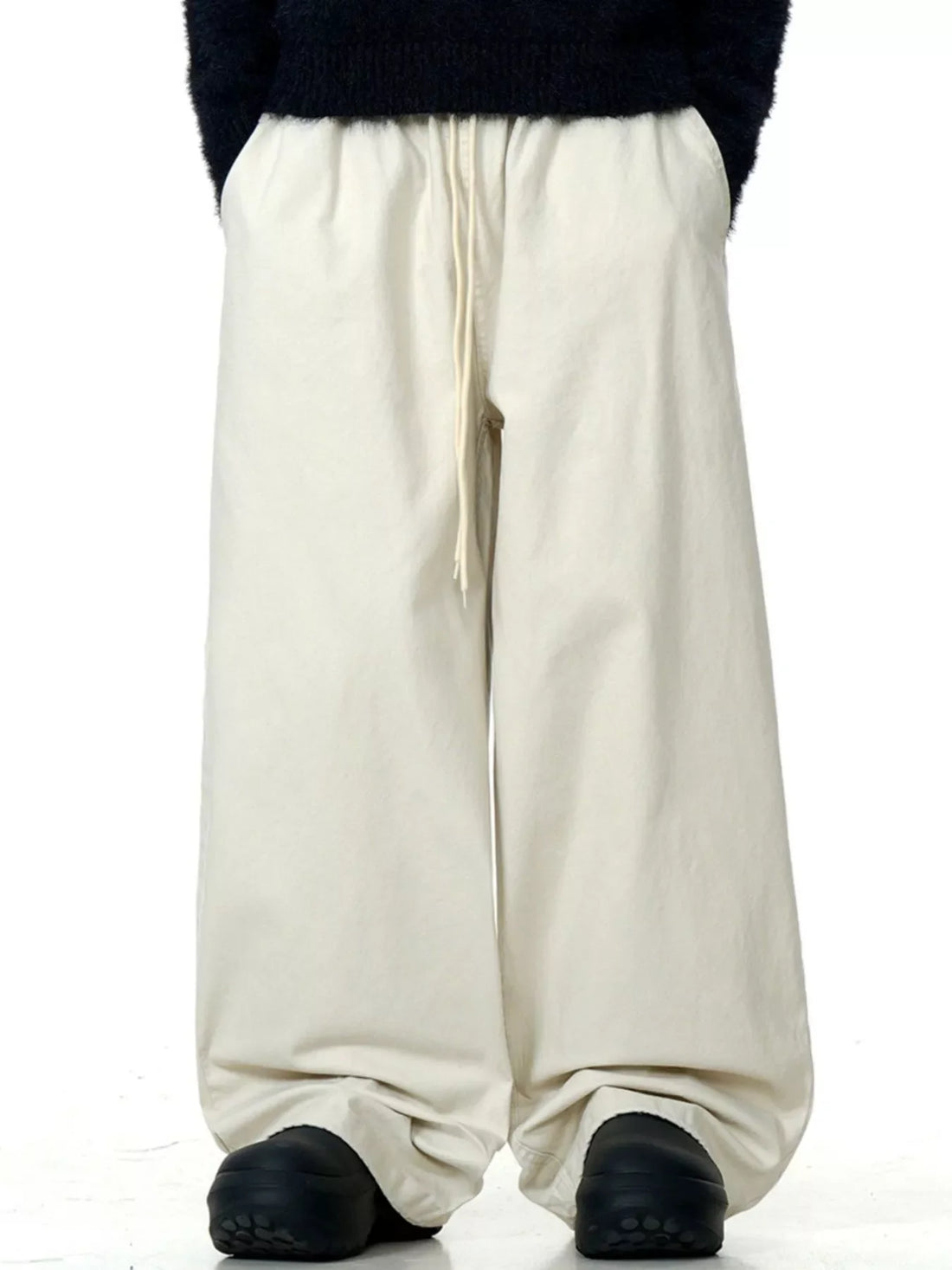 Light beige wide-leg drawstring trousers with a relaxed fit.