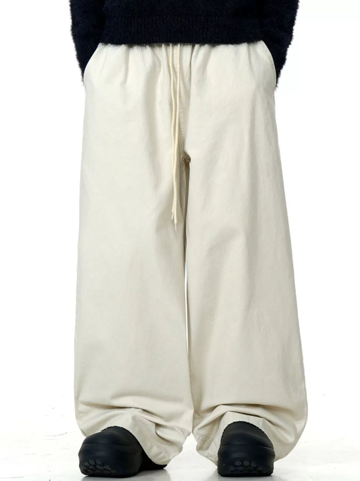 Light beige wide-leg drawstring trousers with a relaxed fit.