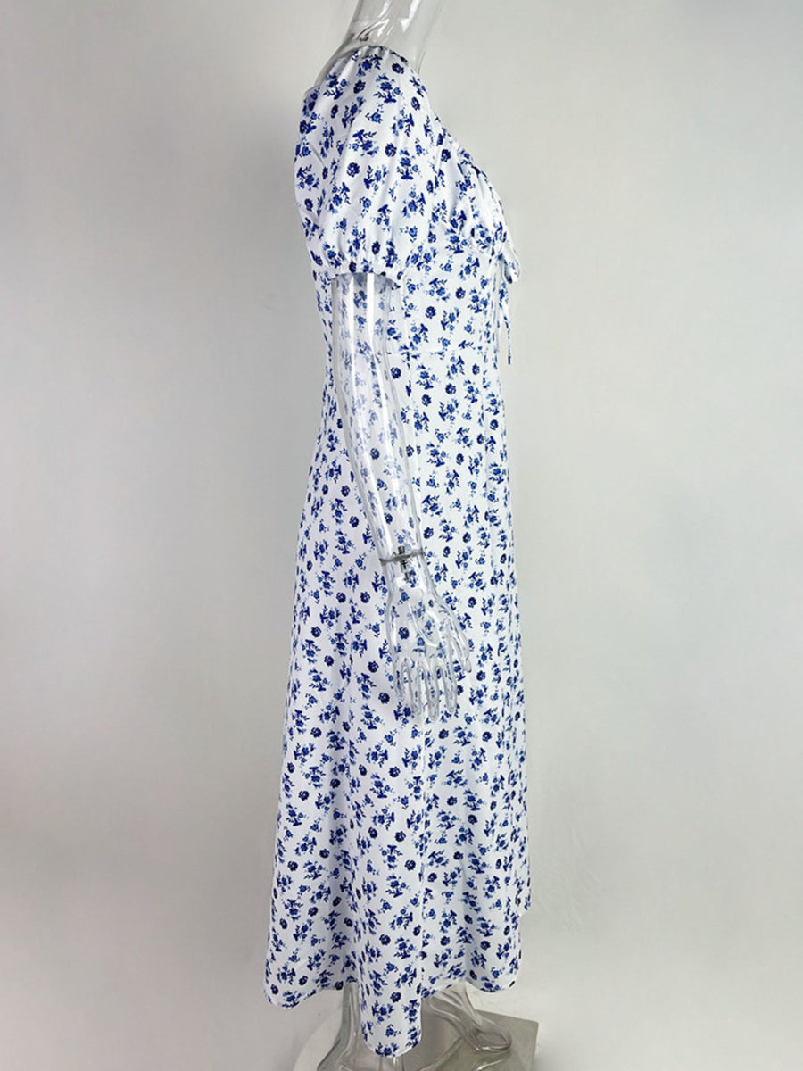 White midi dress with blue floral print, tie front, and short sleeves.