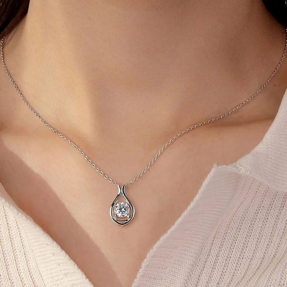 Silver teardrop moissanite pendant necklace with a sculpted sterling silver setting.