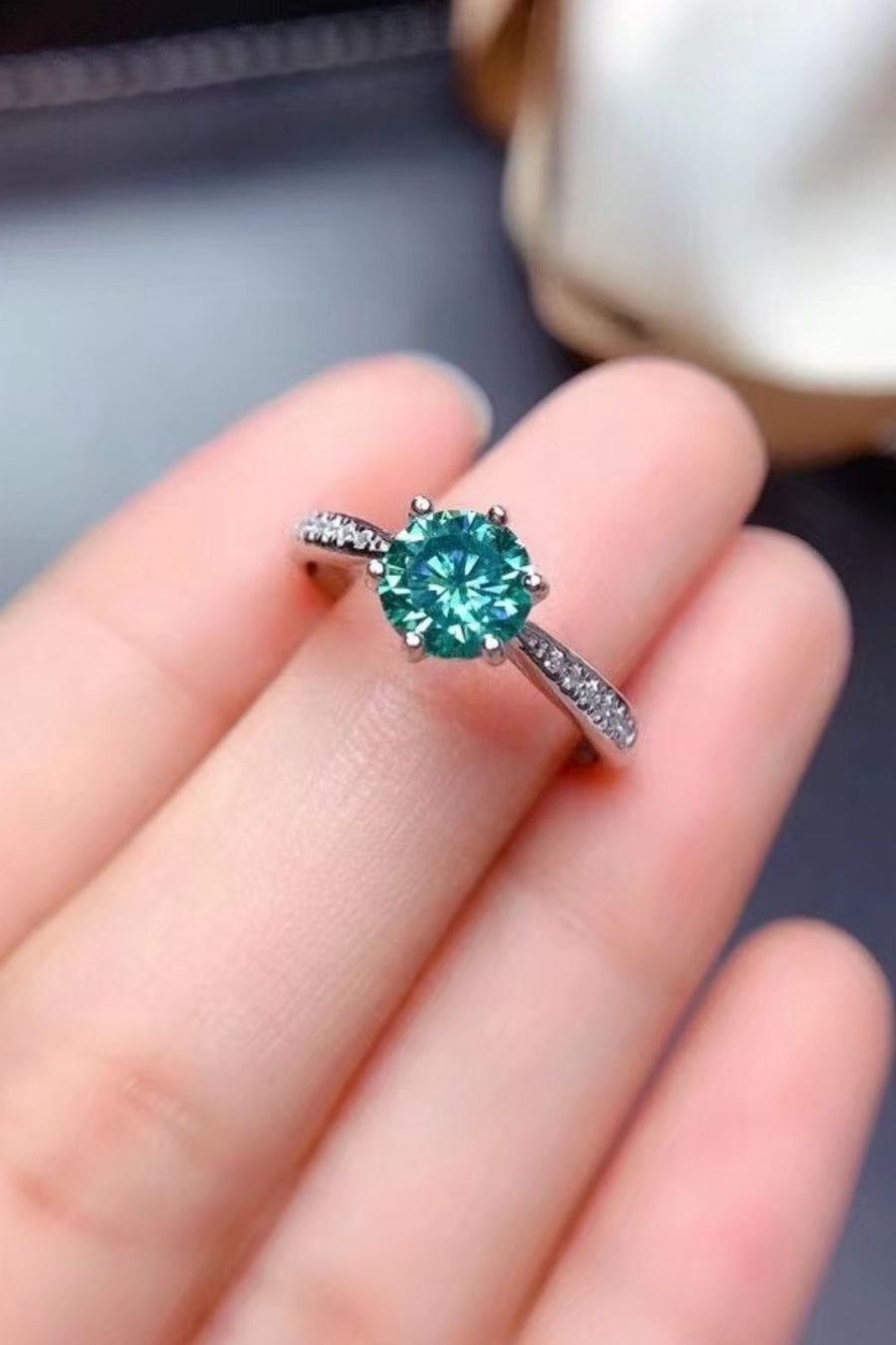 Teal moissanite solitaire ring with pave band in silver.