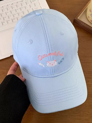 Light blue baseball cap with embroidered cat and fish design.