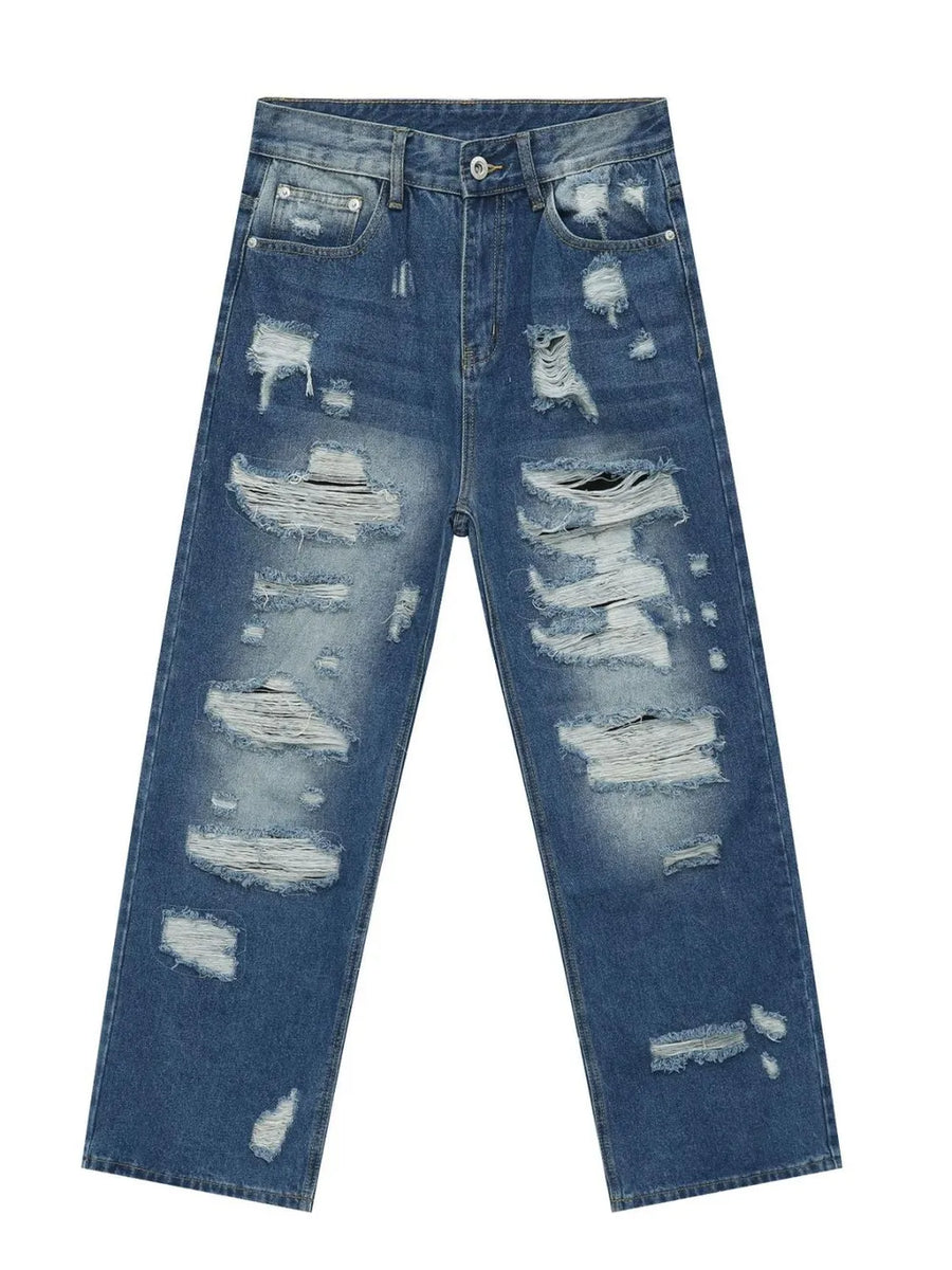 Oversized ripped denim jeans in medium wash with raw edge detail and distressed accents.