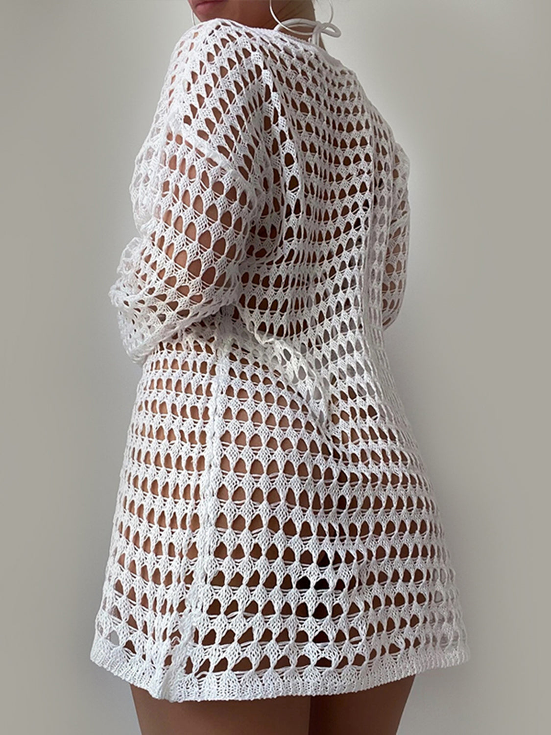 White open-knit beach dress with long sleeves and a boatneck, styled casually.