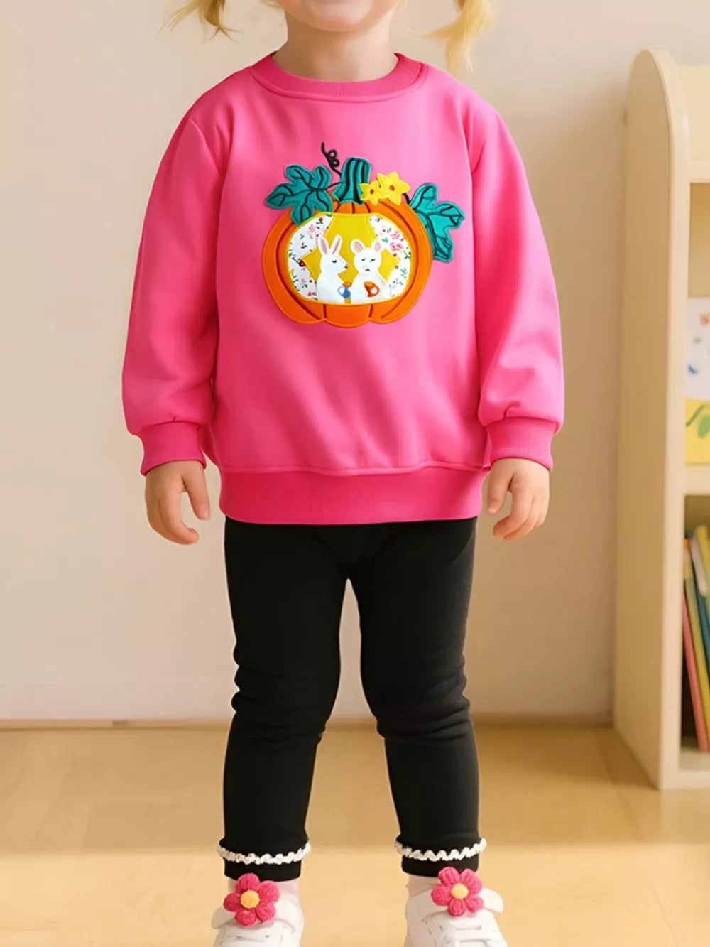 Pink cotton crew neck sweatshirt with pumpkin applique featuring bunnies.