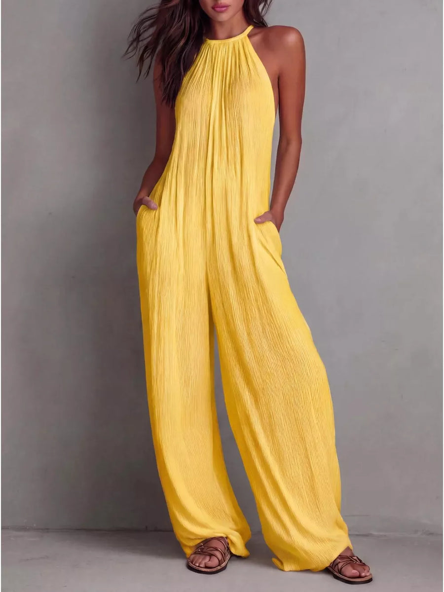 Yellow wide-leg halter jumpsuit with pockets and crinkle texture.