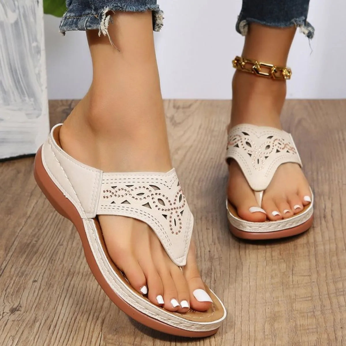 White laser-cut thong sandals with architectural detailing and a comfortable contoured sole.