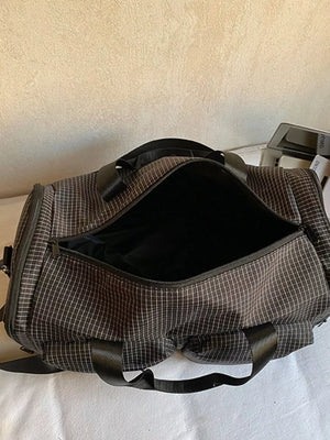 Chic medium plaid duffel bag with pockets and black straps.