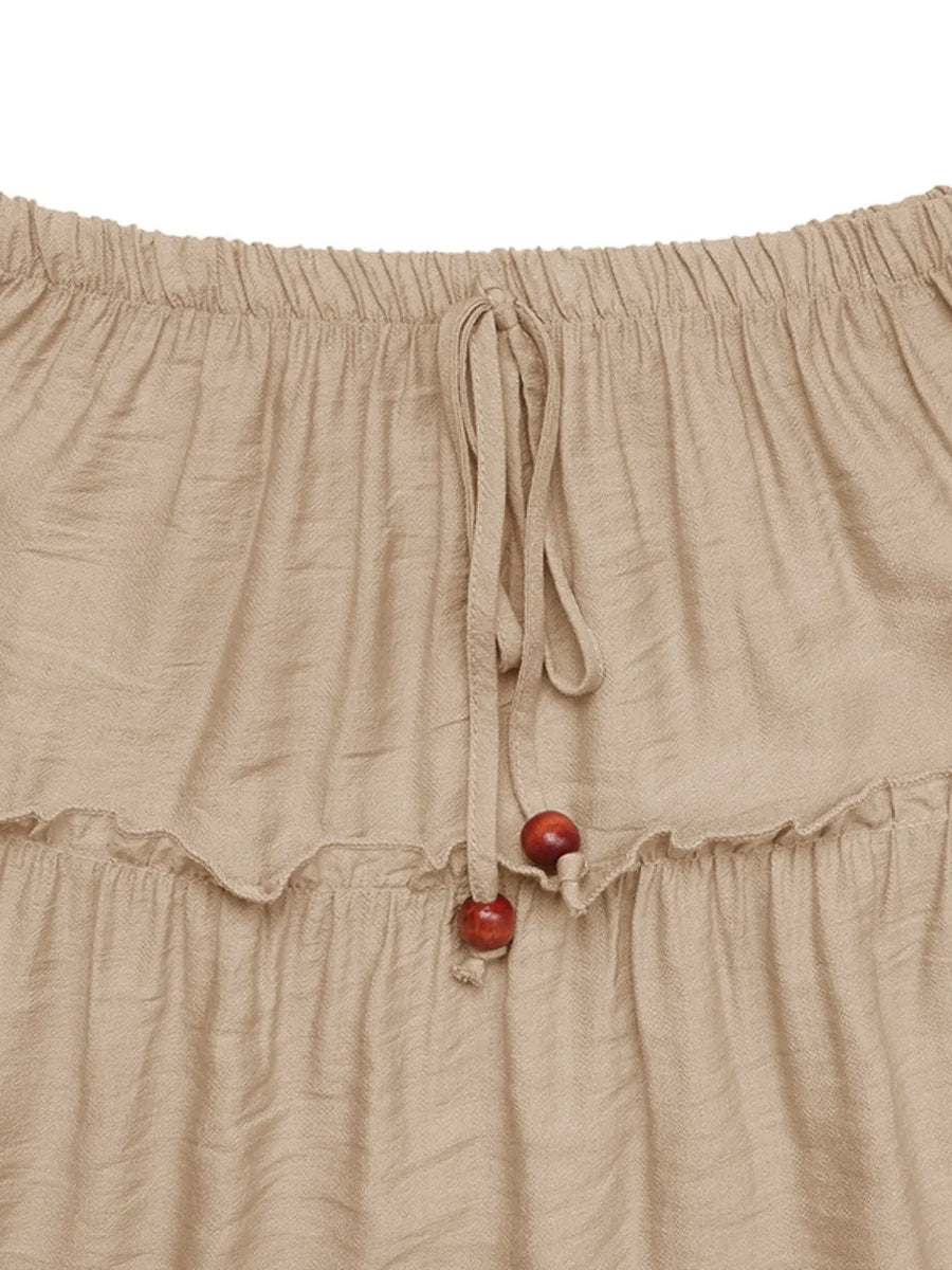 Tiered maxi skirt in tan with drawstring waist and wooden beads.