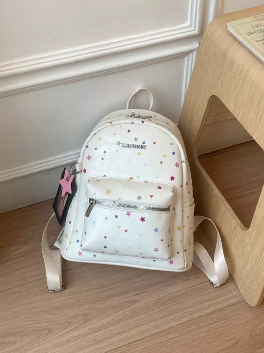 White mini backpack with colorful star print and front zip pocket.