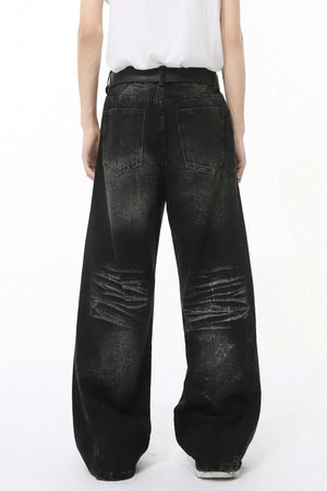 Faded black denim palazzo trousers with distressed detailing and wide legs.