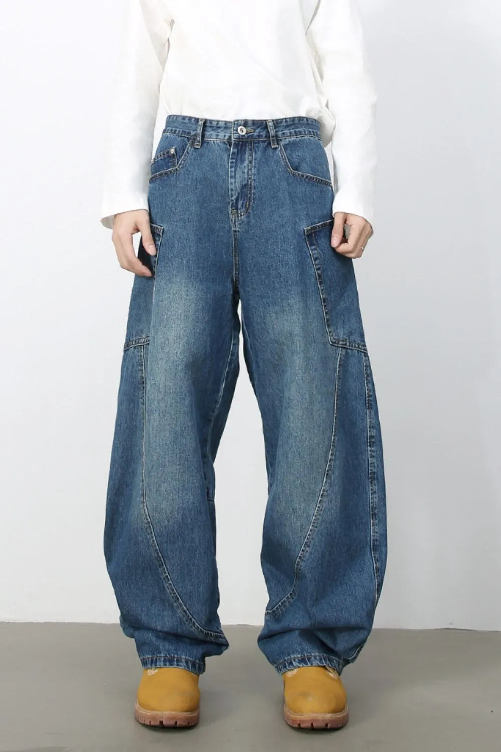 Medium wash denim balloon trousers with unique paneling and a relaxed fit.