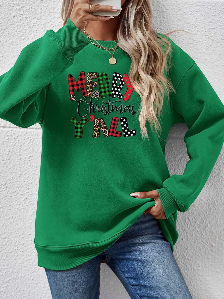 Green crewneck sweatshirt with "Merry Christmas Y'all" graphic in mixed prints and patterns.