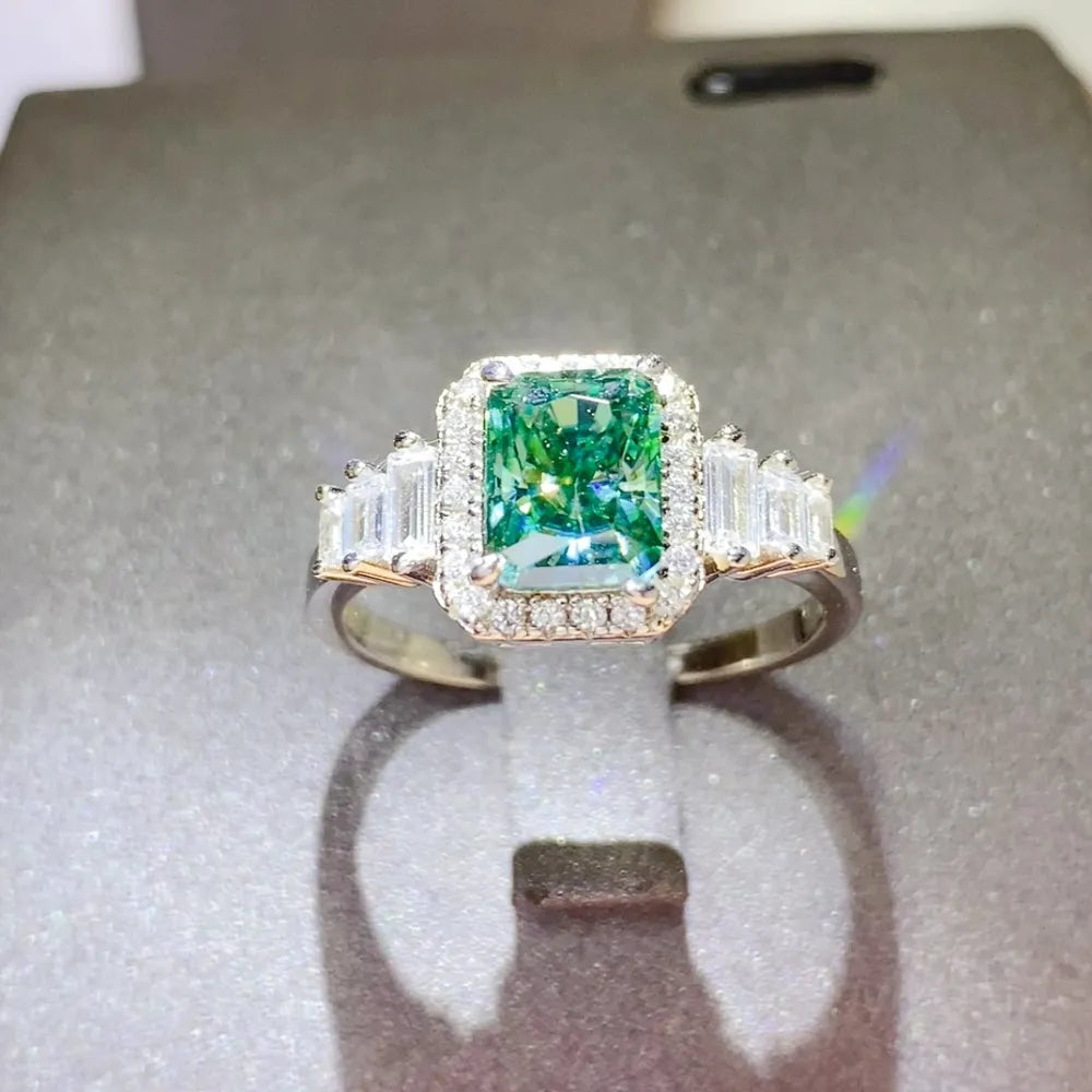 Emerald-cut moissanite halo ring in silver with baguette side stones.