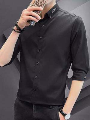 Black cotton button-down shirt with contrasting buttons and embroidered collar detail.