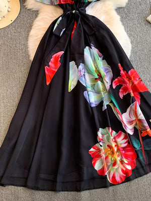 Black off-shoulder a-line dress with a bold floral print and belted waist detail.